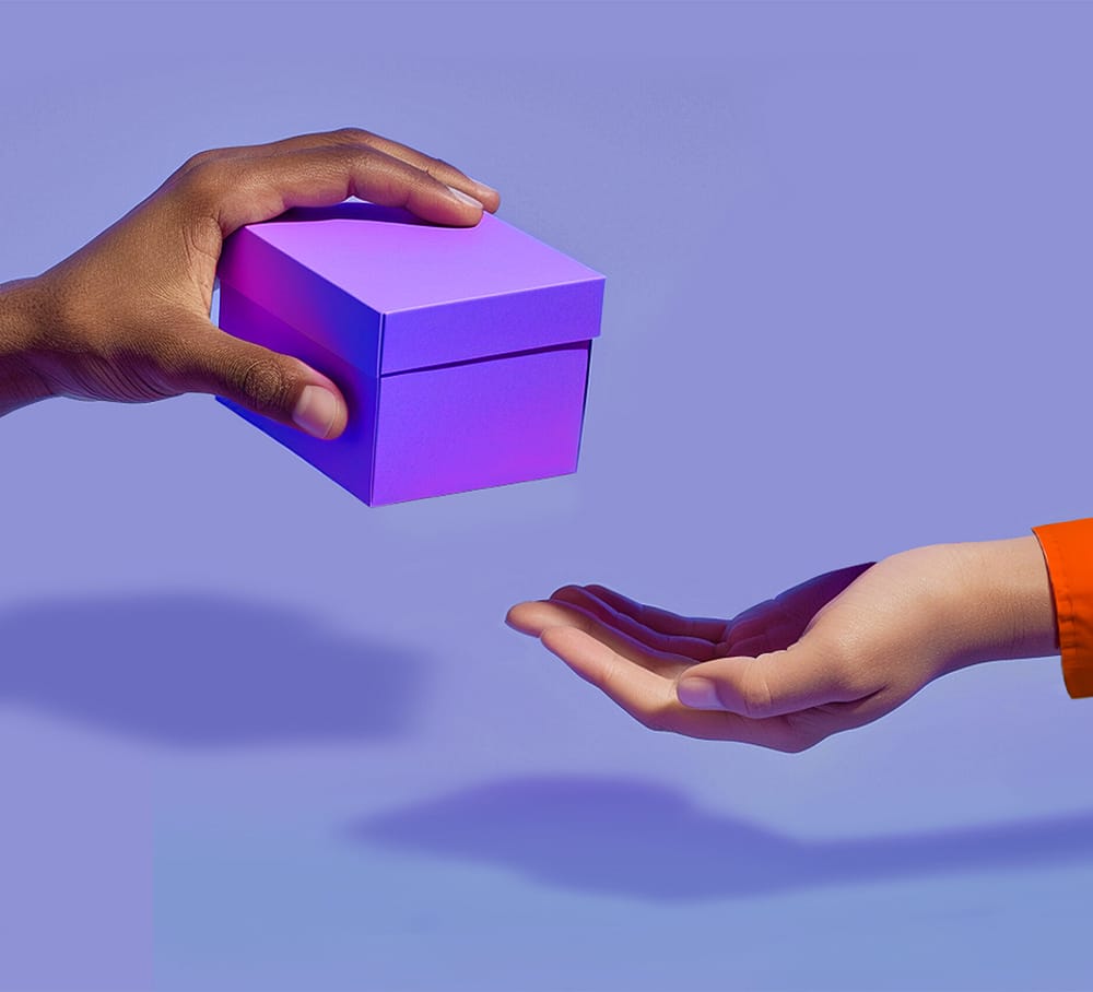 Eine Person überreicht einer anderen eine Gutschein-Geschenkbox